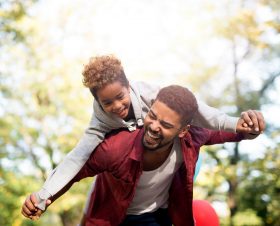 father-holding-his-daughter-on-shoulders-and-laughing